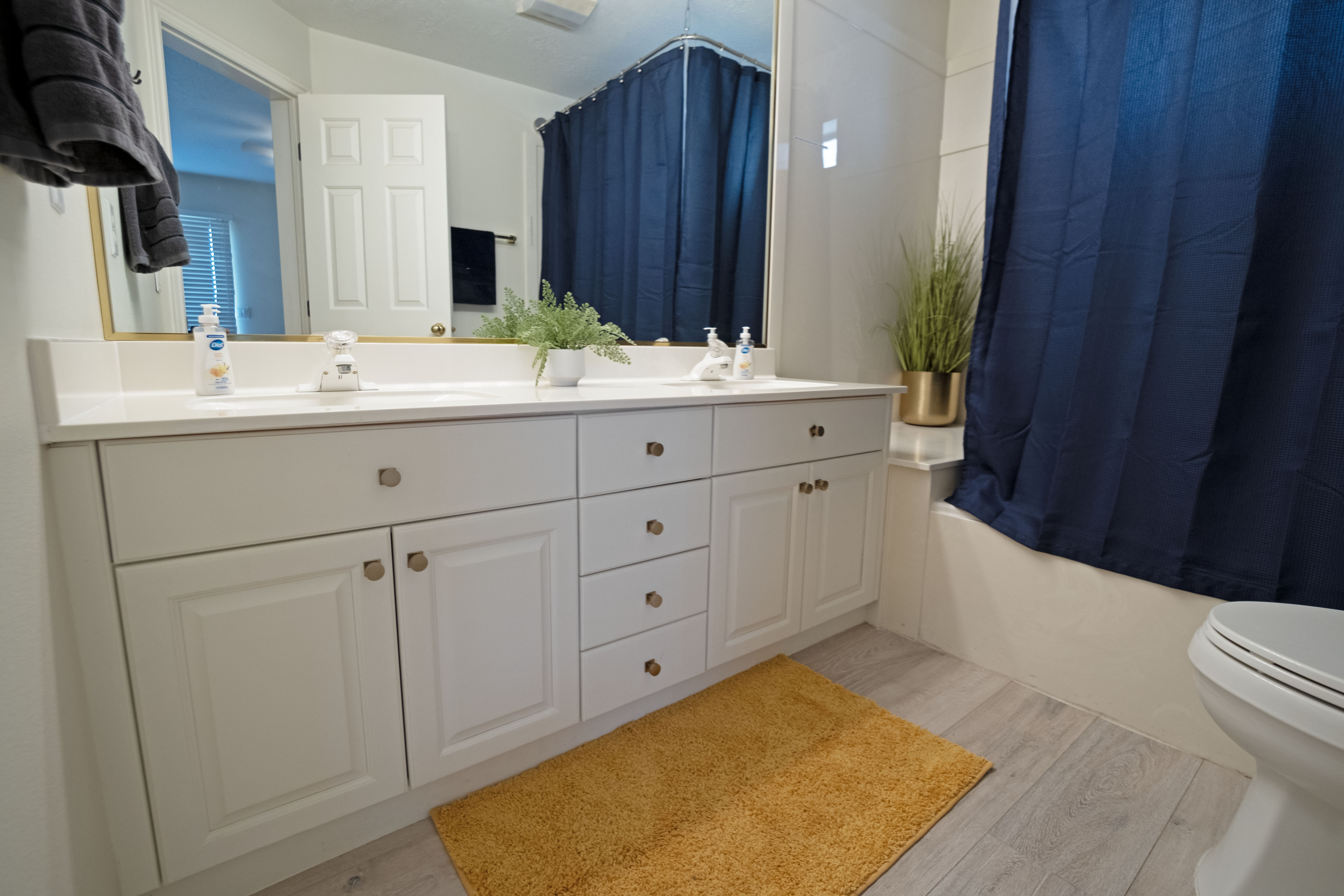 Primary bathroom, double vanity with white cabinetry, a light-toned countertop, and dual sinks