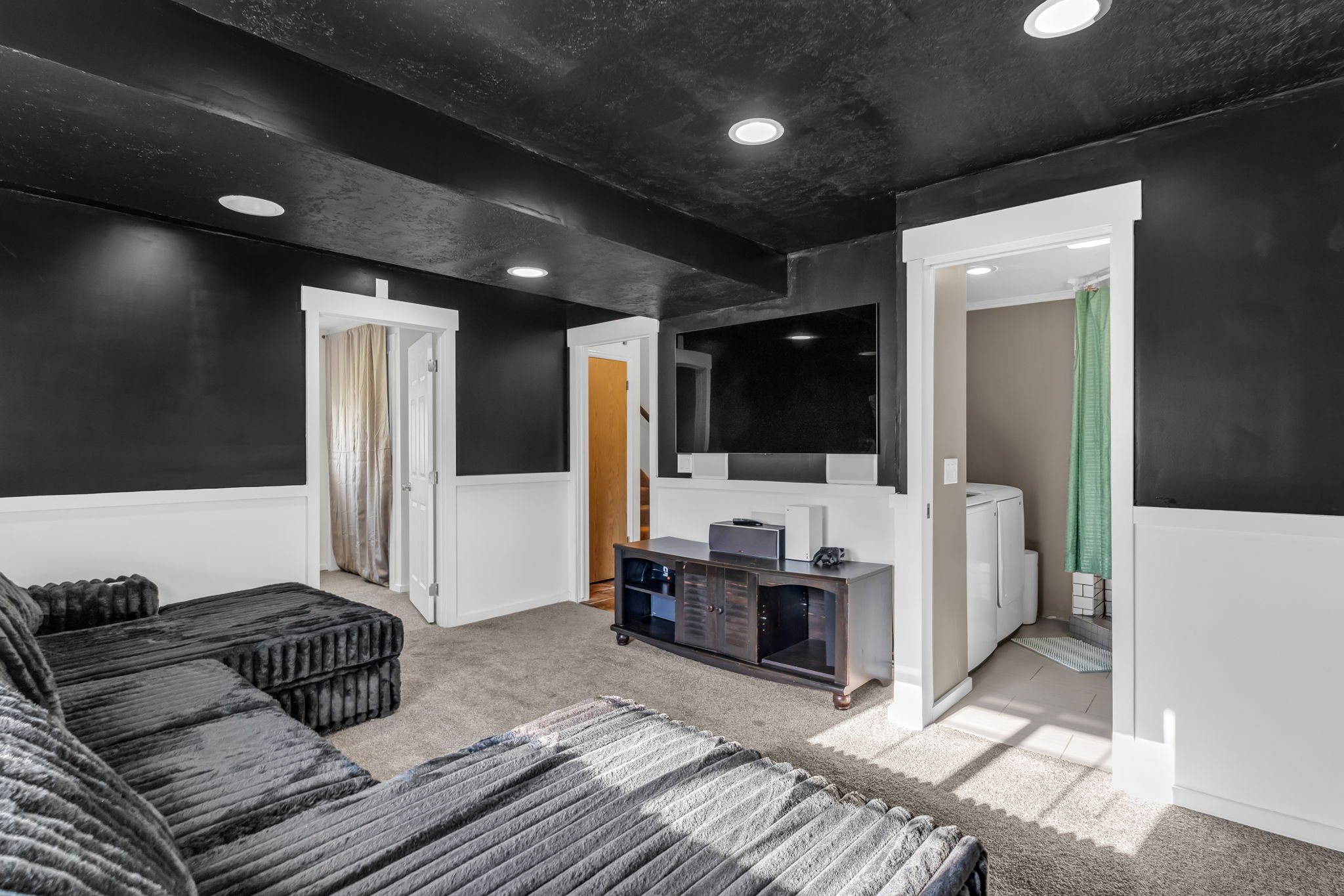 Carpeted interior space featuring a recessed lighting, two-tone walls with wainscoting, and white trim around doorways