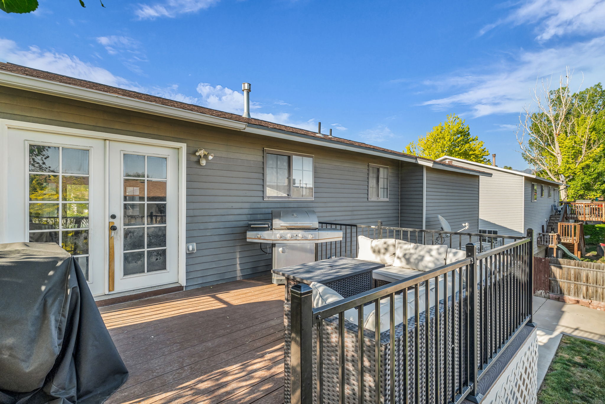 Elevated outdoor deck featuring wood-finish flooring and black metal railings