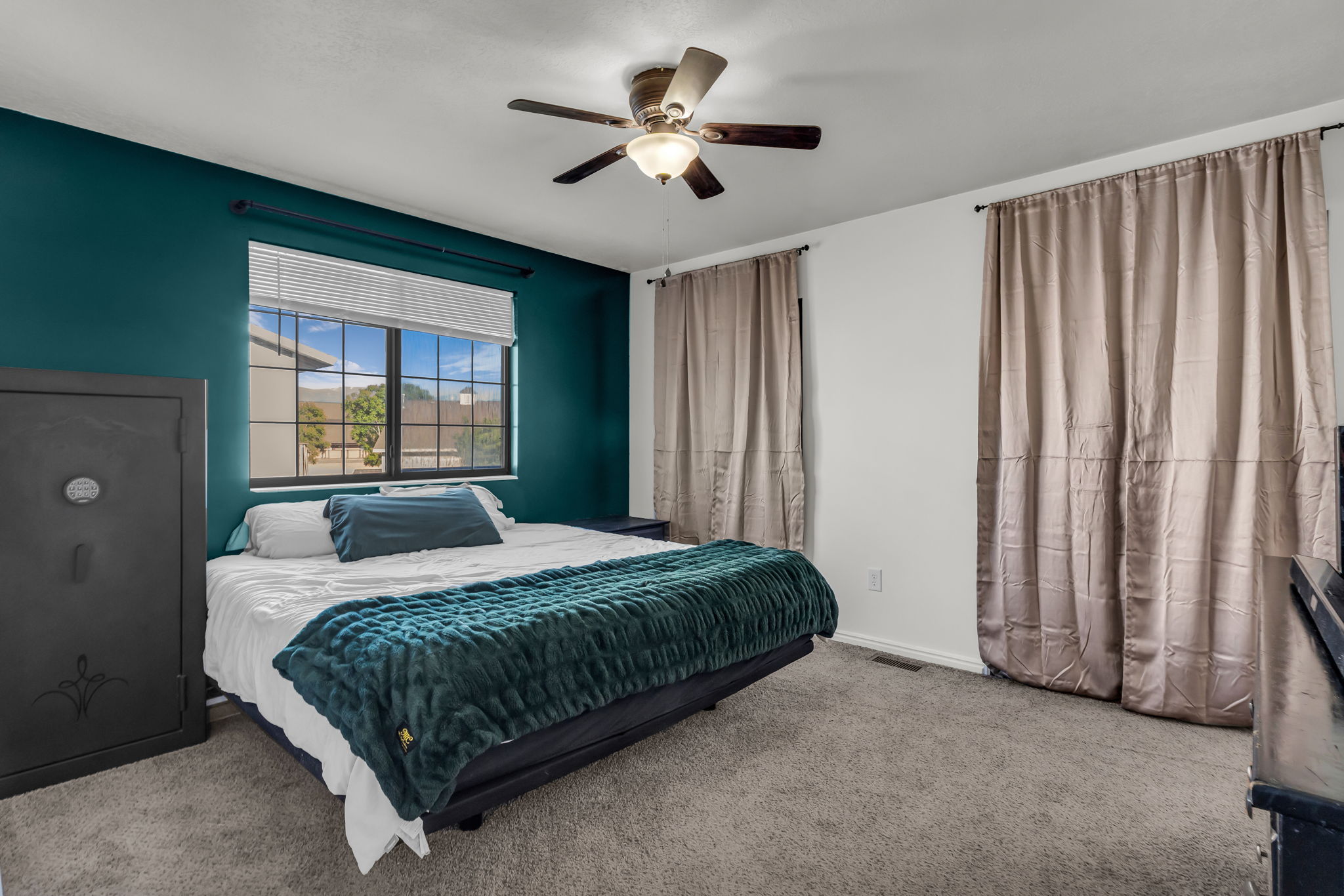 Bedroom featuring a contrasting accent wall and neutral carpeting
