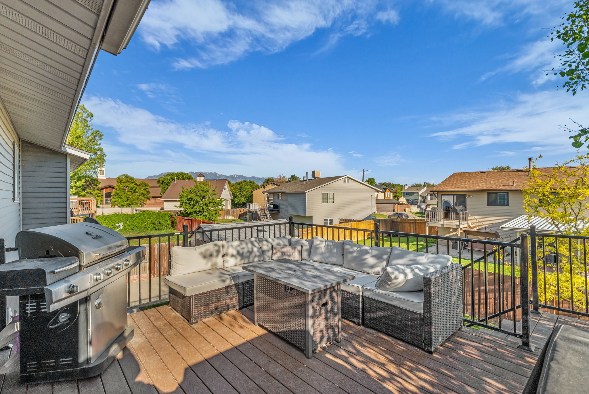 Spacious outdoor deck featuring wood-finish flooring and black metal railings