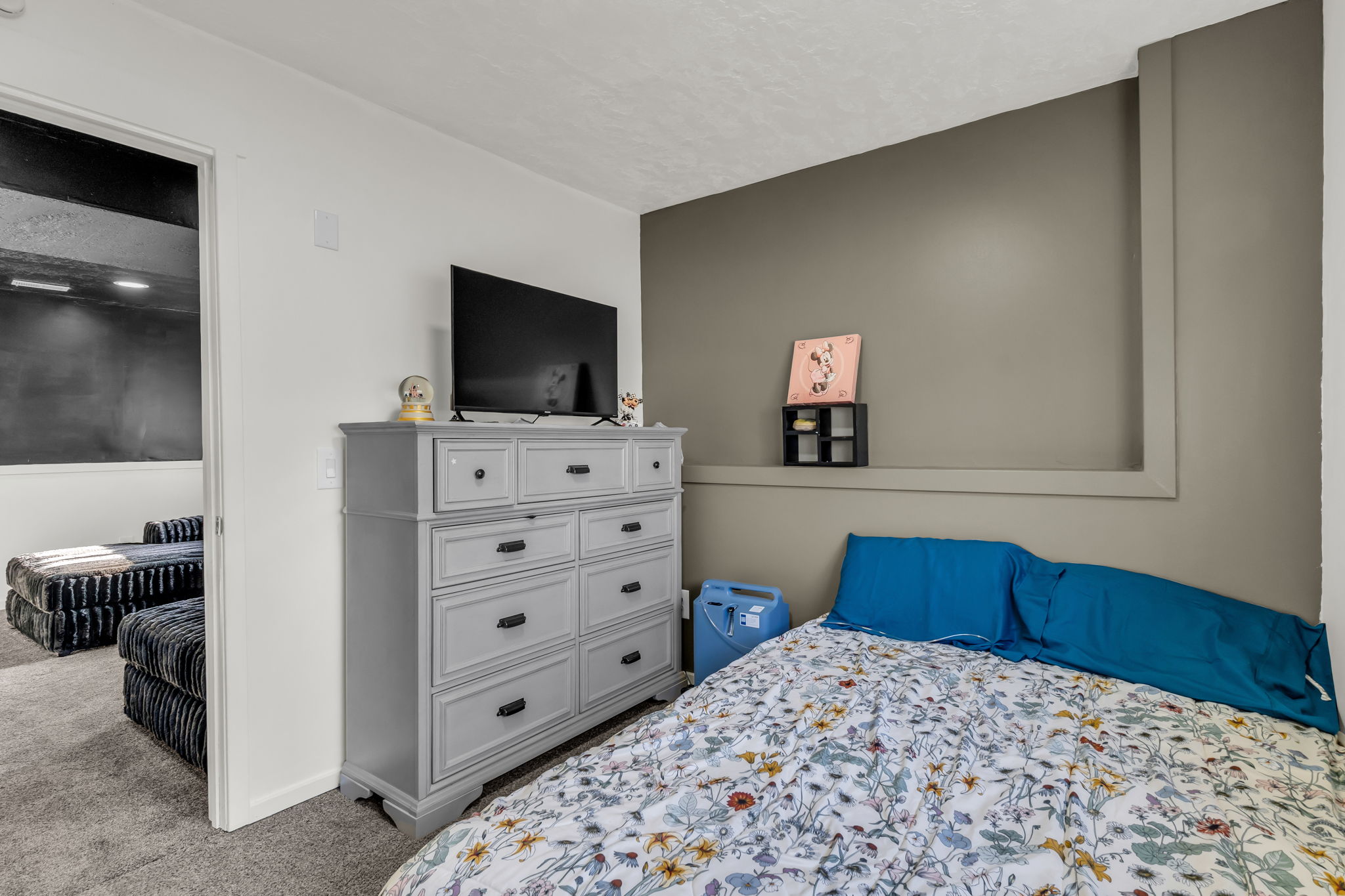Carpeted room featuring a neutral two-tone wall design, including a built-in recessed shelf