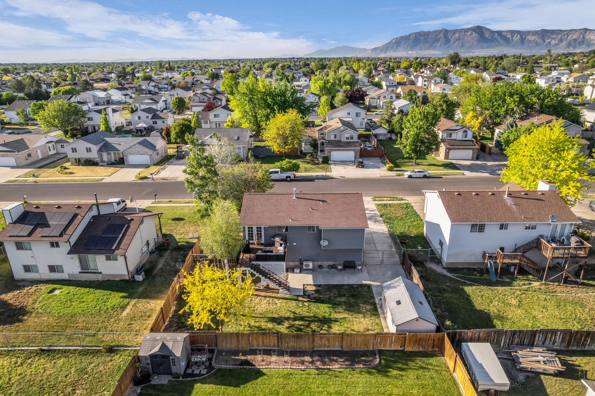 Spacious backyard featuring a wooden privacy fence, a detached shed, and mature trees