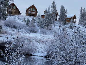 Wood-sided residences with prominent gable roofs and multiple balconies, nestled among snow-covered evergreen trees