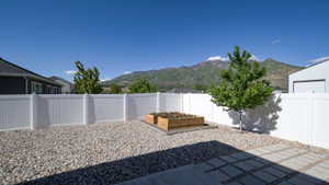 Outdoor space featuring a white privacy fence and a mountain backdrop