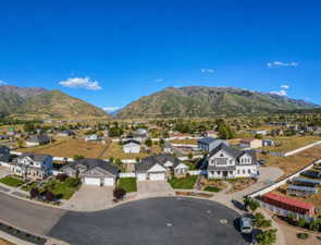 Residential neighborhood featuring mountain backdrops, paved streets, and manicured lawns