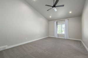 Spacious room featuring a vaulted ceiling with recessed lighting, a ceiling fan, light gray wall paint, and gray carpet flooring