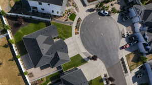 Property featuring a dark shingle roof, green lawn, and paver patio