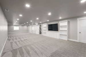 Spacious room featuring patterned gray carpet flooring, recessed lighting, and light gray wall paint