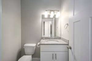 White vanity with a light-toned stone countertop and undermount sink