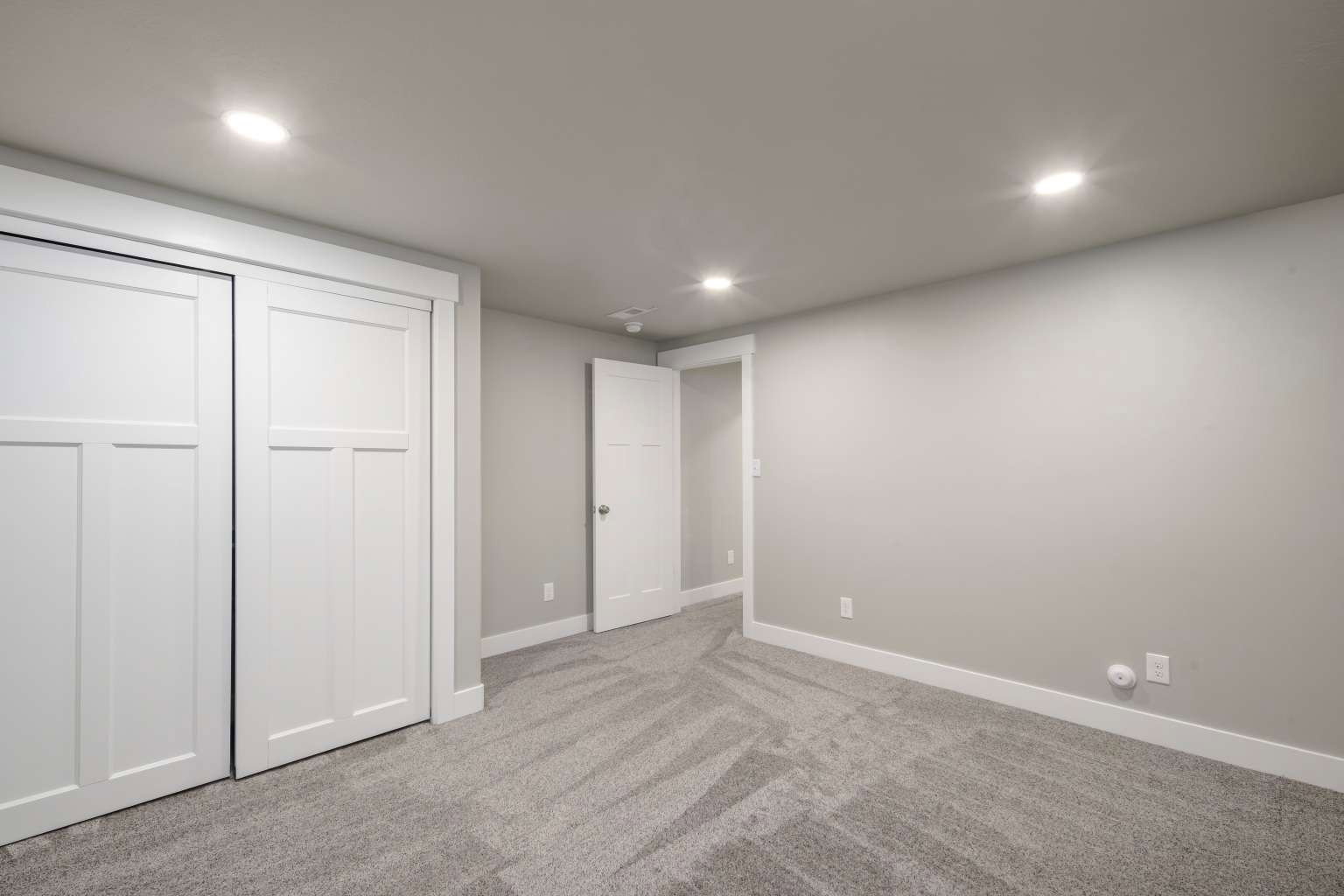 Bedroom featuring gray wall paint, light gray patterned carpet, white baseboards, and bright recessed lighting