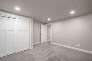 Bedroom featuring gray wall paint, light gray patterned carpet, white baseboards, and bright recessed lighting