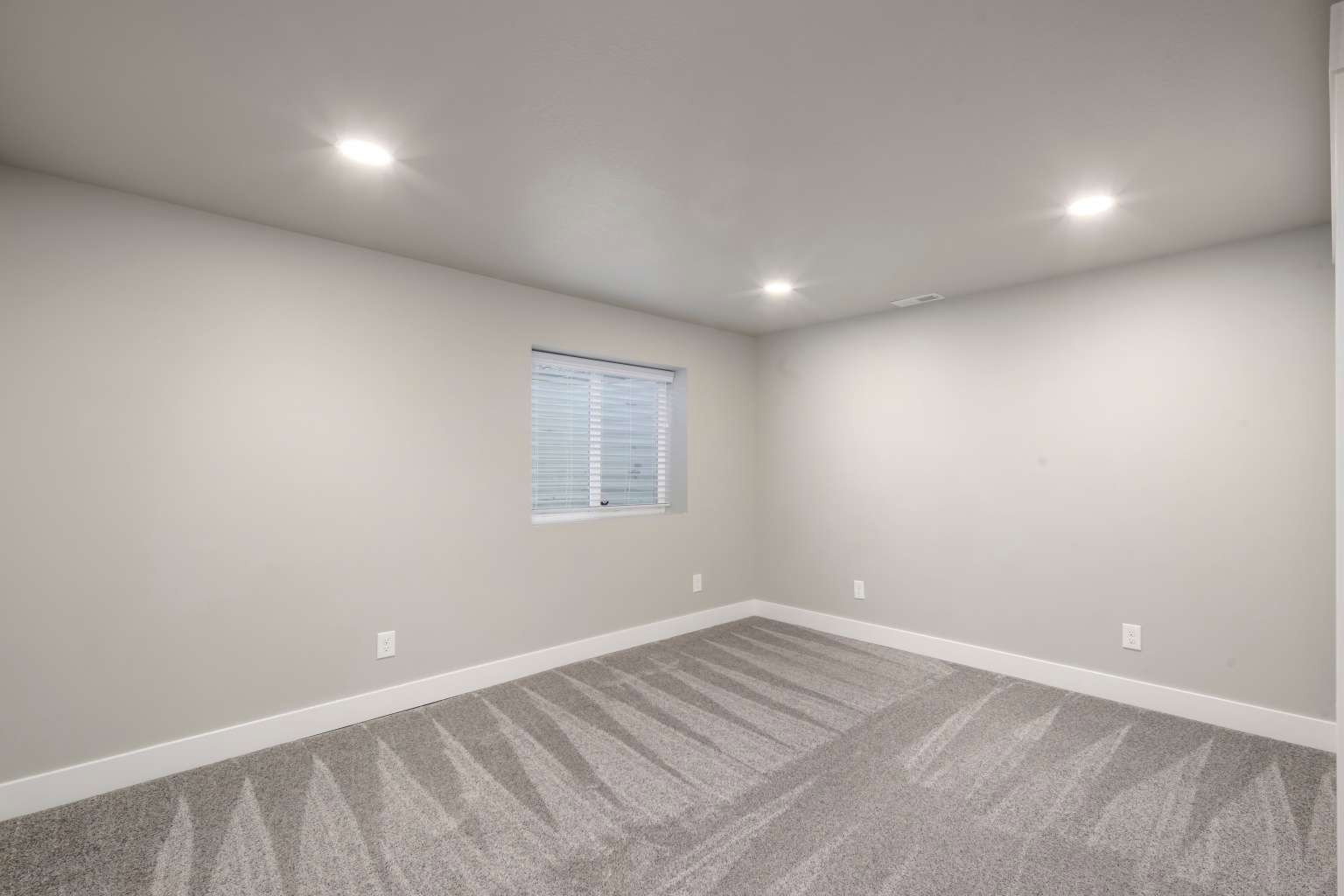 Neutral tone walls with white trim and recessed lighting