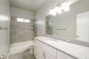 Bathroom featuring a white vanity with a light speckled countertop, an integrated sink, and an extended mirror