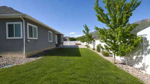 Expansive lawn bordered by a rock garden and mature trees