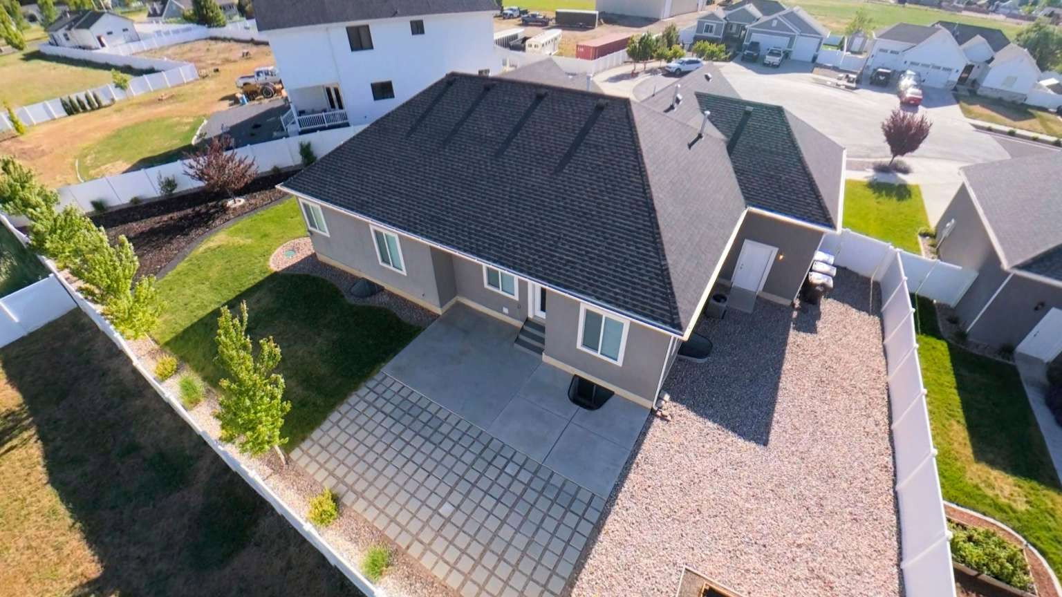 Contemporary ranch-style residence featuring a dark shingle roof and light gray siding