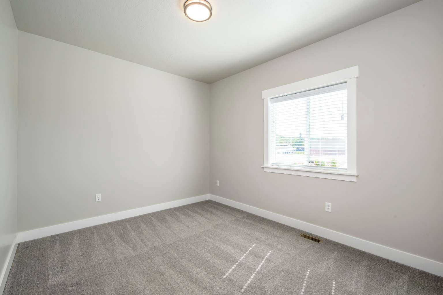 Neutral-toned walls complement the gray patterned carpeting