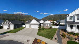 Modern ranch-style residence featuring a gray exterior with white trim accents and a dark roof