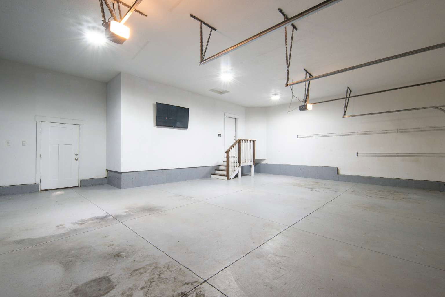 Spacious garage featuring a concrete floor, painted walls, and built-in overhead lighting