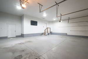 Spacious garage featuring a concrete floor, painted walls, and built-in overhead lighting
