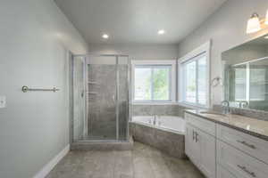 Spacious bathroom featuring a glass-enclosed shower, a corner built-in tub, a double vanity with stone countertop, and tile flooring