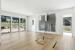 Open-concept room featuring light wood-finish flooring, white walls, and recessed ceiling lighting