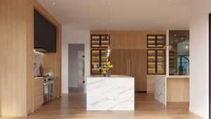 Gourmet kitchen with a waterfall island, integrated appliances, natural wood cabinetry, and a full-height marble-finish backsplash