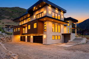 Contemporary multi-level exterior featuring stacked stone and wood-finish siding