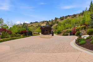 Expansive stone-finish driveway with a central gatehouse structure