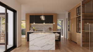 Expansive kitchen featuring a waterfall island with stone countertop, wood-finish flooring, custom cabinetry with integrated appliances, and multiple pendant light fixtures
