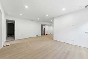 Spacious interior featuring light wood-finish flooring, recessed lighting, and white walls