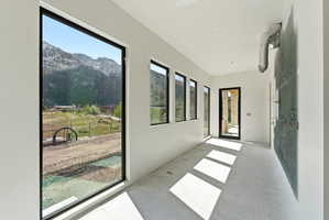Room with multiple large windows, offering expansive mountain scenery