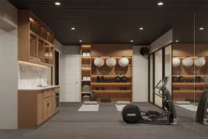 Dedicated fitness space featuring textured carpet flooring, a dark slatted ceiling, recessed lighting, and a mirrored wall