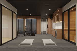 Dedicated fitness space featuring textured carpet flooring, wood-paneled walls, and recessed lighting