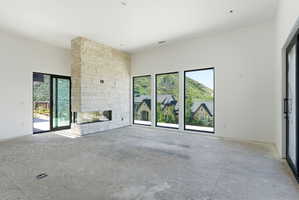 Expansive interior space featuring a floor-to-ceiling stone-clad fireplace with a linear firebox