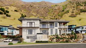 Contemporary multi-level residence featuring a light-colored stone facade, multiple balconies with glass railings, large windows, and a prominent front entrance with arched double doors