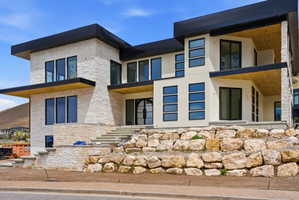 Modern architectural design featuring stacked stone and smooth stucco exterior finishes