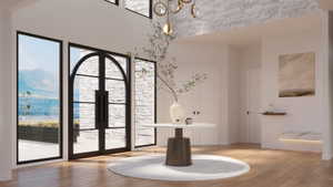 Grand entry featuring a custom arched double door with sidelights, a textured stone accent wall, high ceilings, and wood-finish flooring
