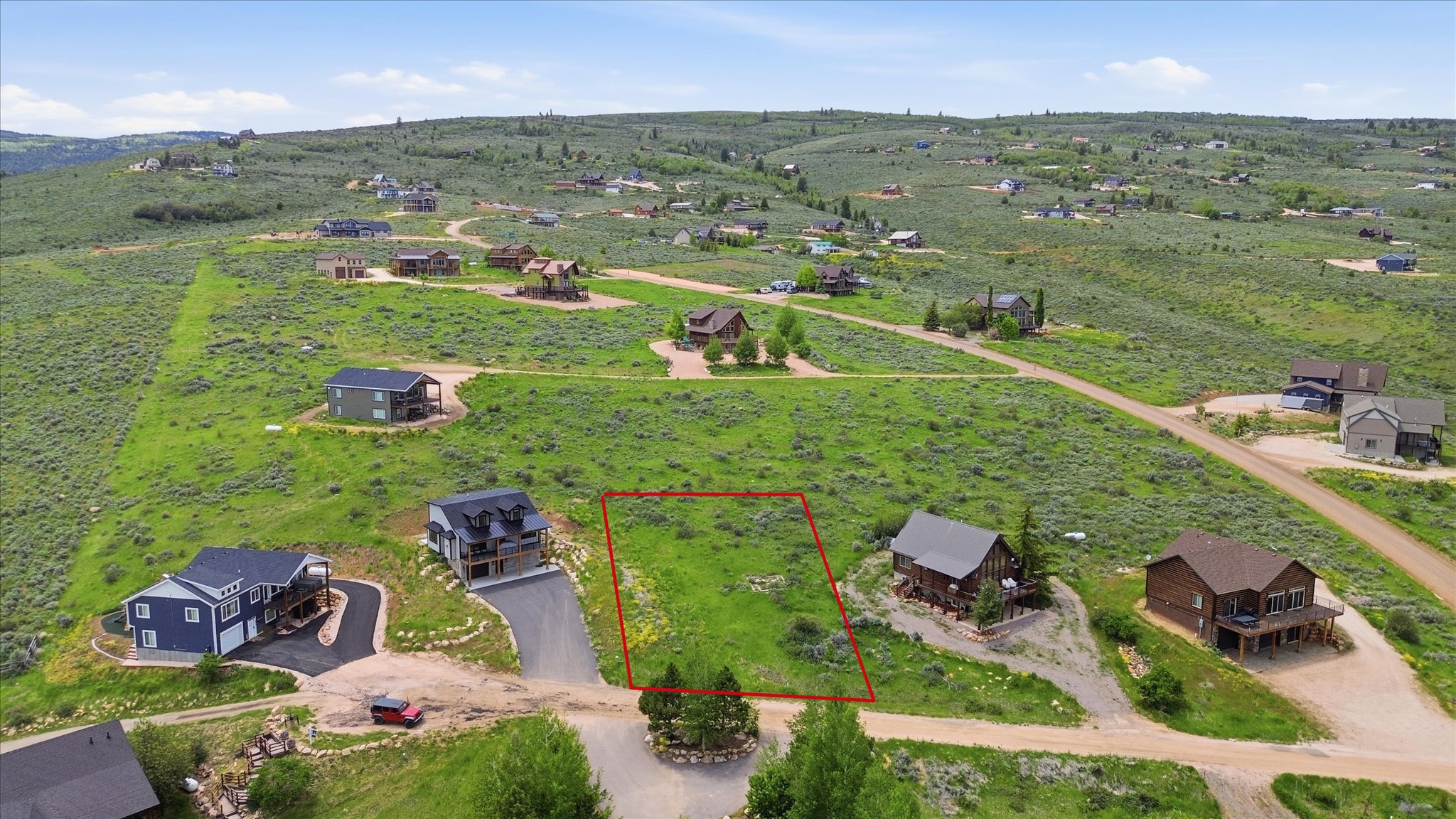 Vacant lot outlined in red, featuring natural vegetation and a gentle slope