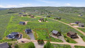 Vacant lot outlined in red, featuring natural vegetation and a gentle slope