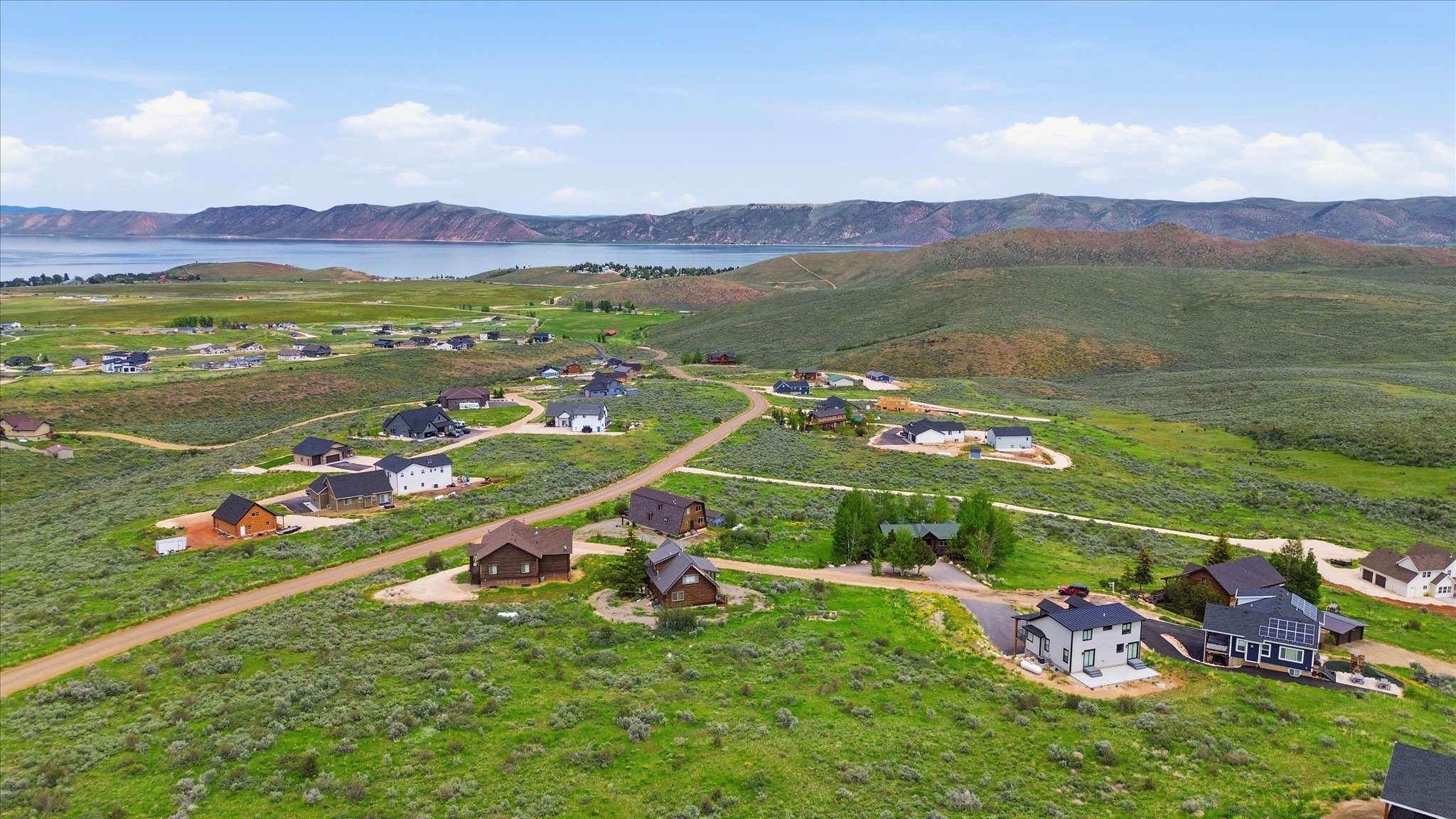 Expansive hillside community featuring a water body and distant mountain range