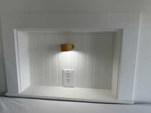Built-in wall niche with beadboard backing, integrated lighting, and a power outlet