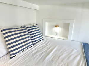 Built-in bunk bed with an integrated recessed niche featuring wood-finish wall paneling, a wall-mounted light fixture, and a power outlet