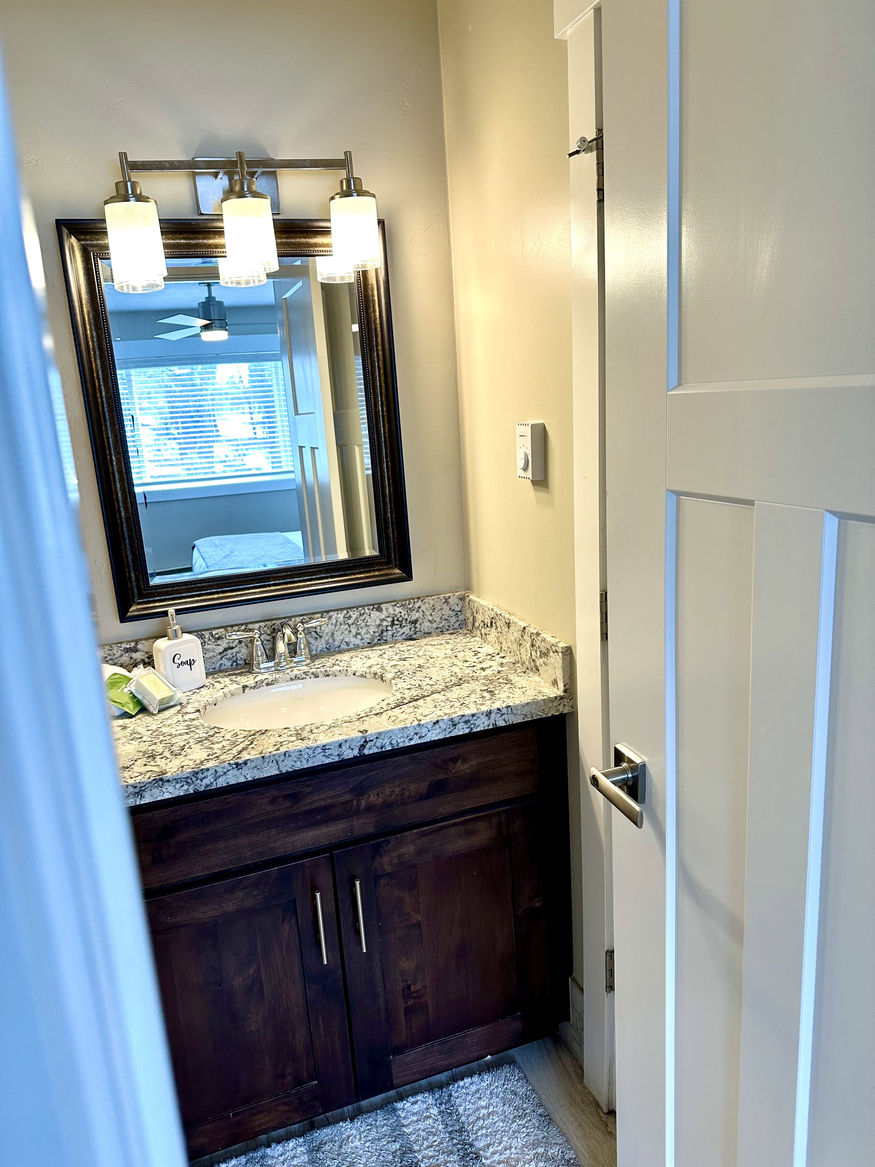 Bathroom vanity with a dark wood-finish cabinet and brushed nickel hardware