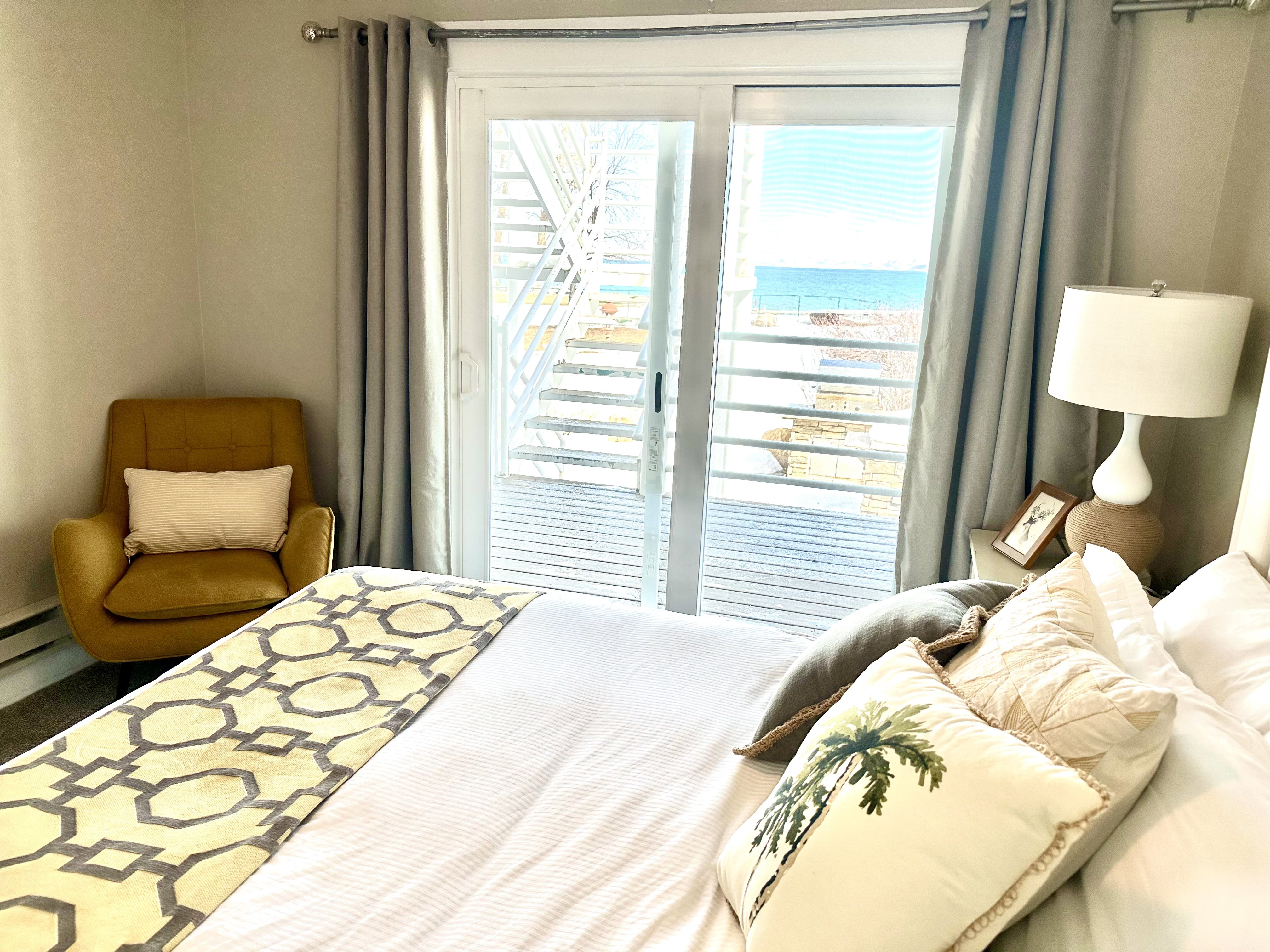 Sliding glass doors open to a private deck with water scenery