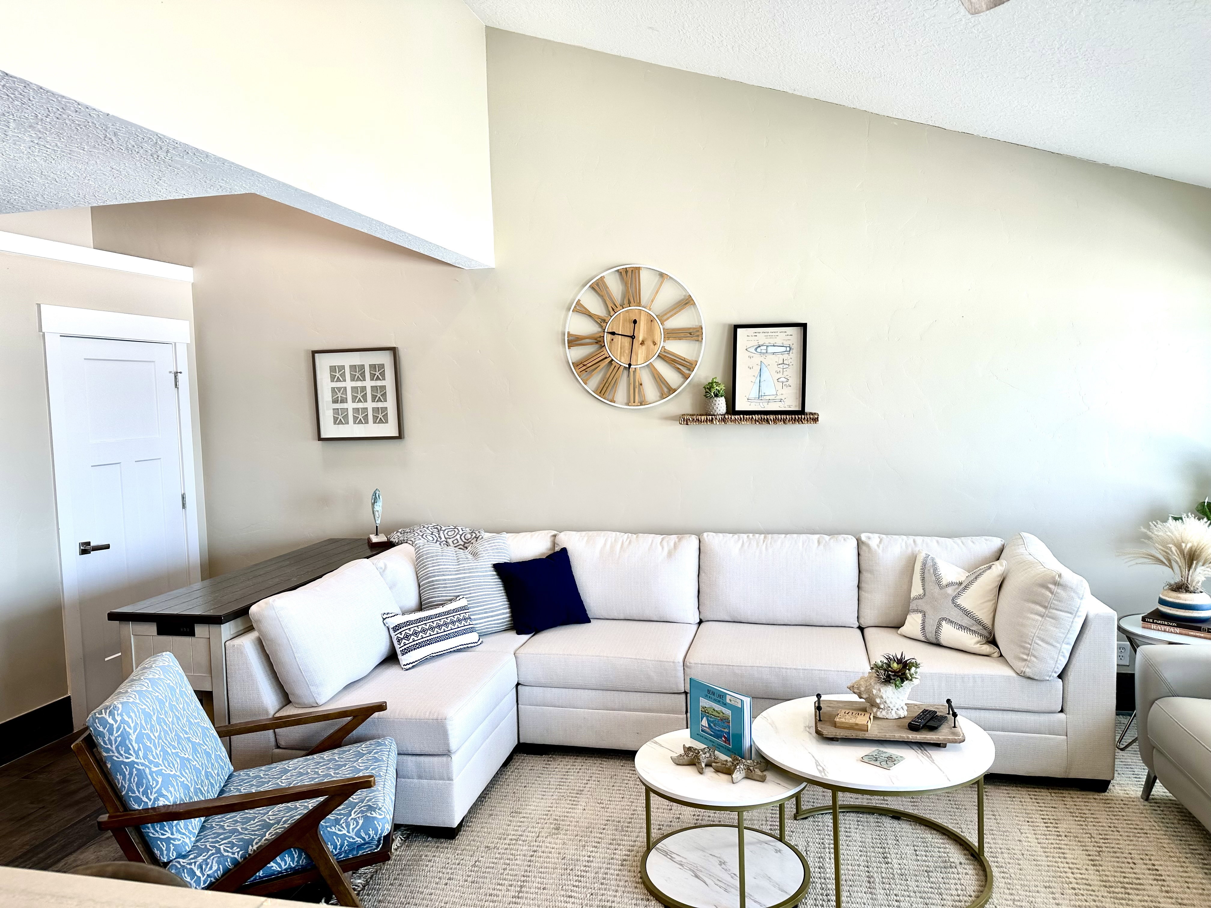 Vaulted ceilings above a spacious living area featuring a large sectional sofa and wood-finish flooring