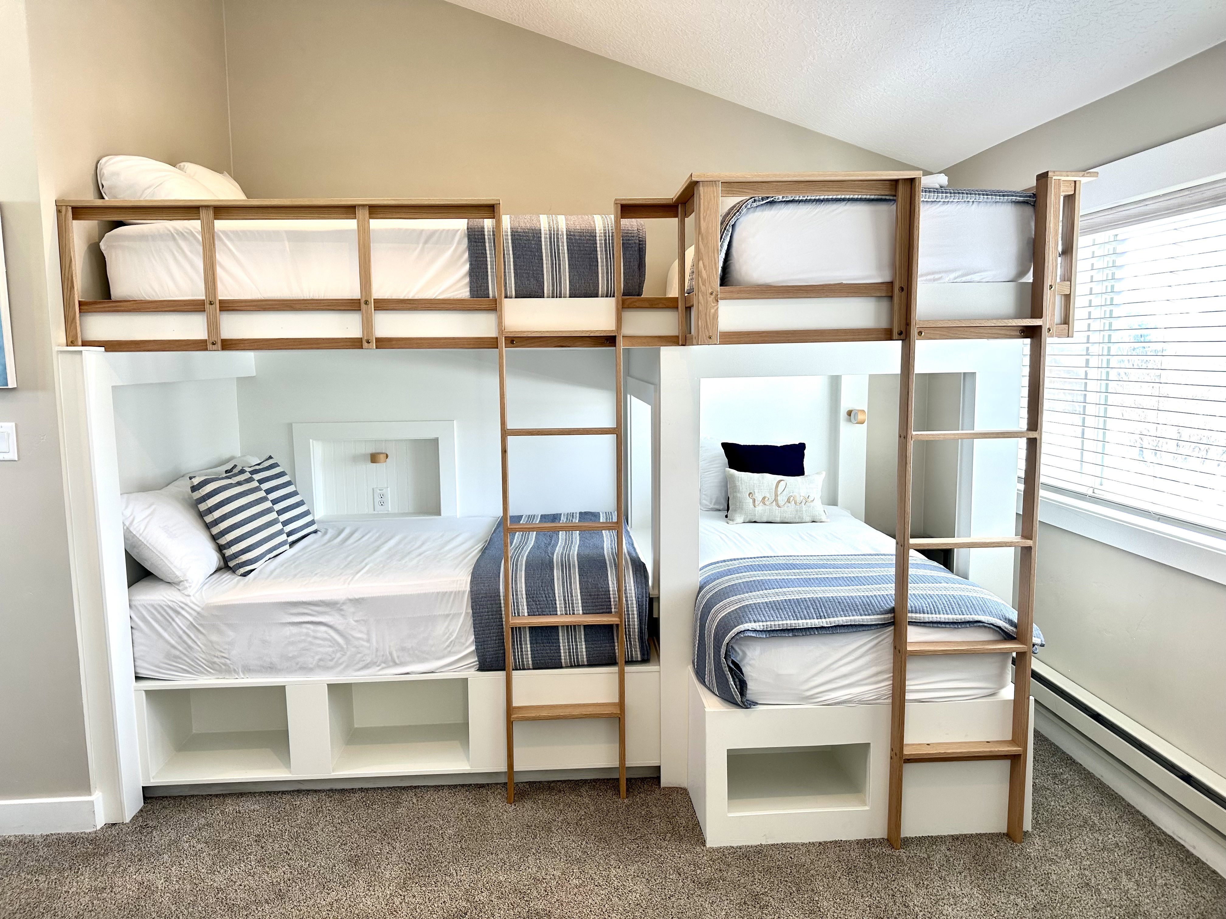 Custom-built bunk beds with integrated storage and natural wood ladders