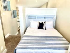 Integrated bed frame with built-in headboard featuring beadboard paneling and shelving