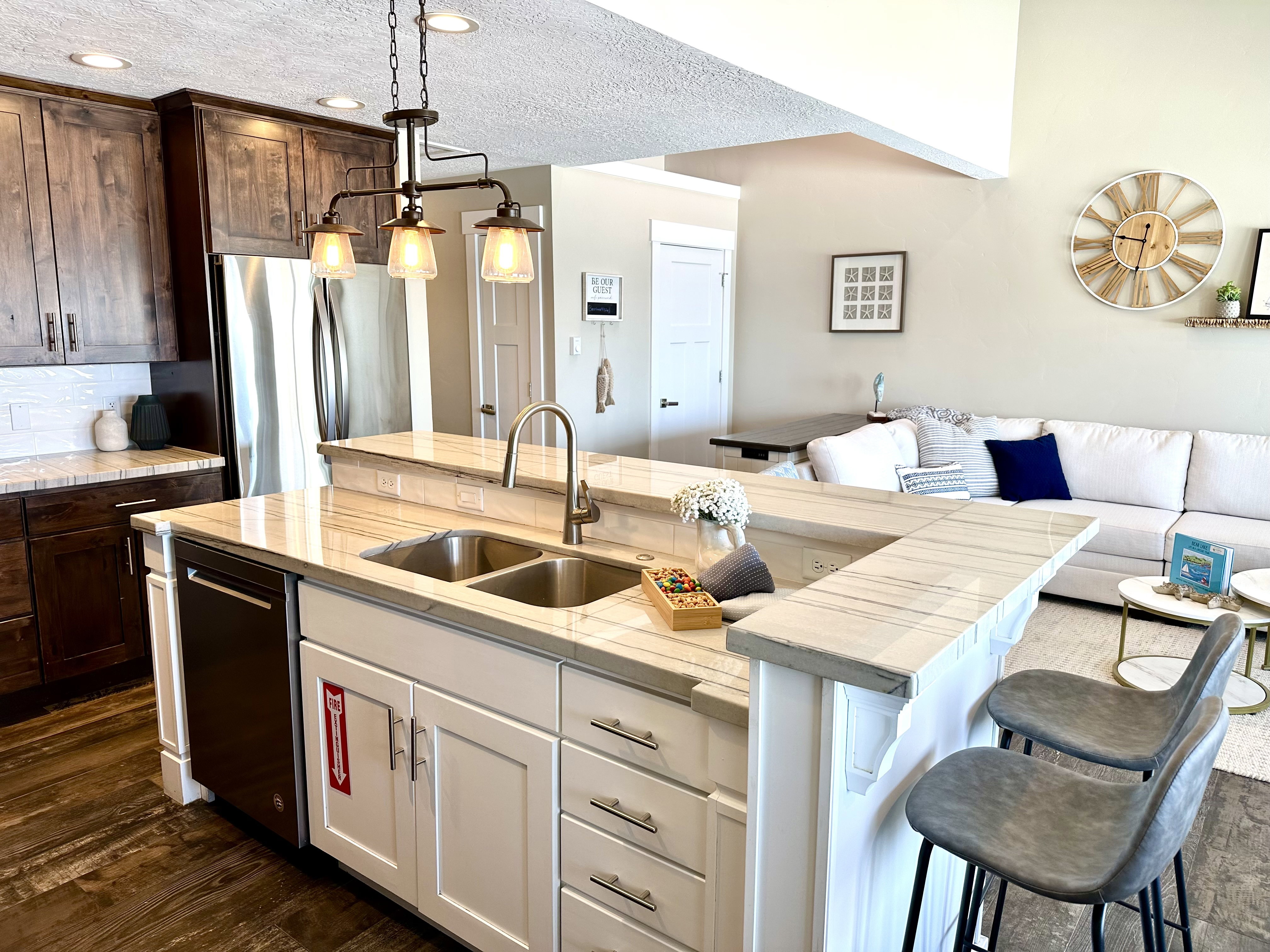 Kitchen featuring a dual-tone cabinetry design, stainless steel appliances, and wood-finish flooring