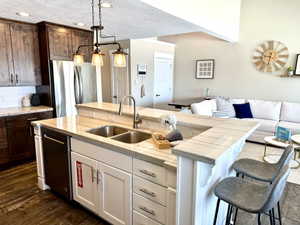 Kitchen featuring a dual-tone cabinetry design, stainless steel appliances, and wood-finish flooring